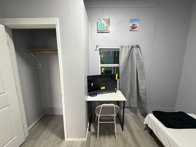 Bedroom includes a dedicated desk/workstation, window with curtain, and a closet for convenient storage.