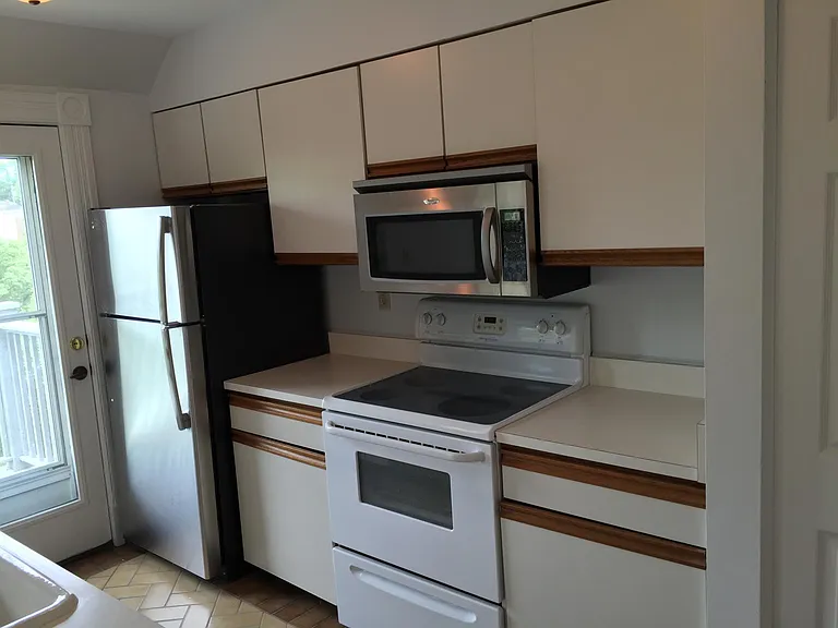 Kitchen with access to the private deck. Appliances: refrigerator, electric stove, microwave and dishwasher