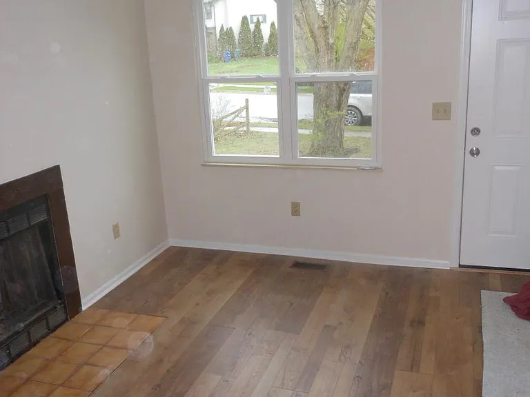 Living room with wood look floors and fireplace. New windows