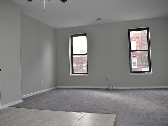There are two large living room windows allowing natural light in throughout the living room/kitchen area.