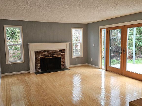 Spacious and light living room with bamboo flooring and French doors leading to deck area.