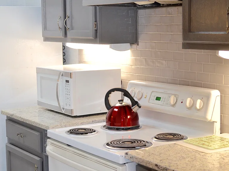 Guest house galley kitchen with electric stove.