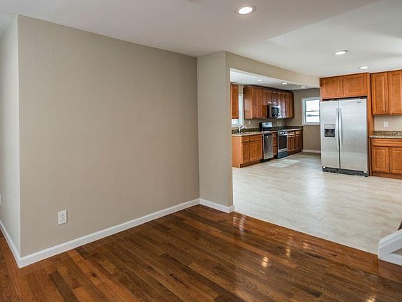 Living room with hardwood floors looking into the open kitch
