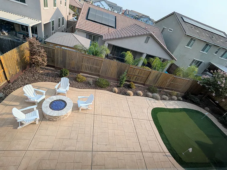 Take in the view of your private backyard oasis. Featuring a professional putting green and inviting fire pit, this immaculate, low-maintenance retreat is built for ultimate relaxation and outdoor fun.