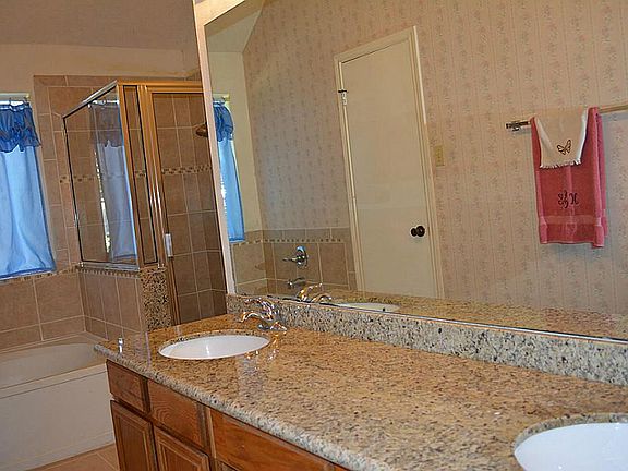 remodeled master bath with granite counters and updated tile flooring
