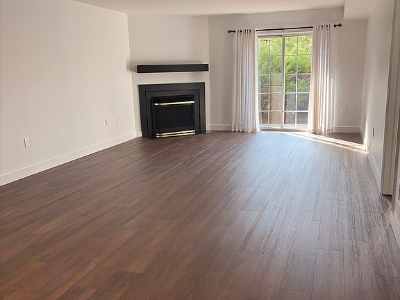 Spacious living/dining room with new flooring and sliding doors to a large private patio.