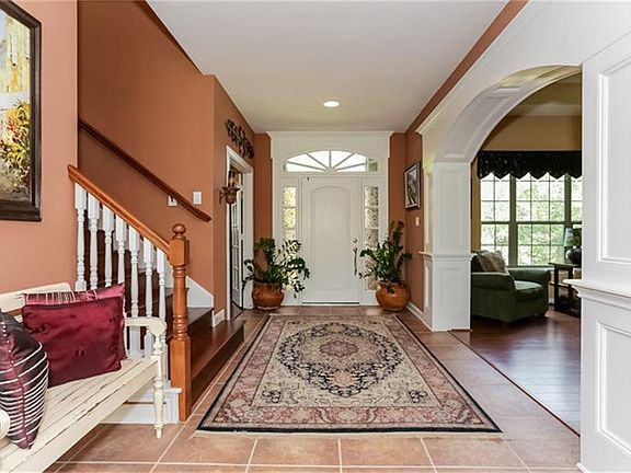 Inviting entry with tile floors and hardwood stairs.