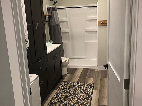 Large bathroom with stackable laundry unit.