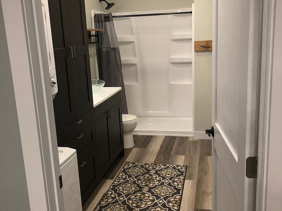 Large bathroom with stackable laundry unit.