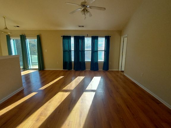 Vaulted great room with triple windows to backyard open to dining and kitchen. New paint. All wood laminate flooring.