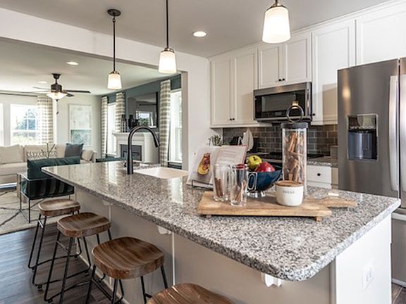 Island kitchen and sunroom extension in a DRB Homes York II Garage Model.