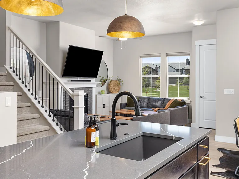 chef's kitchen and living room (furniture pictured is for staging purposes only - unfurnished unit)