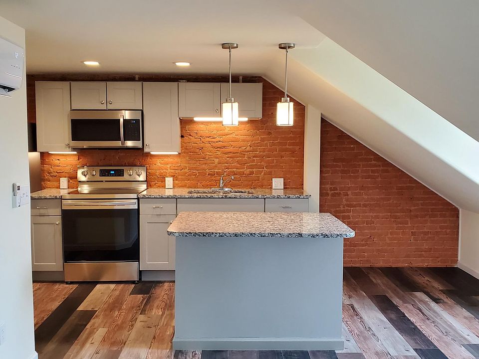 Kitchen with exposed brick, granite countertops, stainless steel appliances