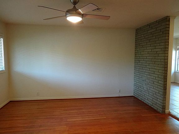 Cozy family with wood floor with updated ceiling fan.