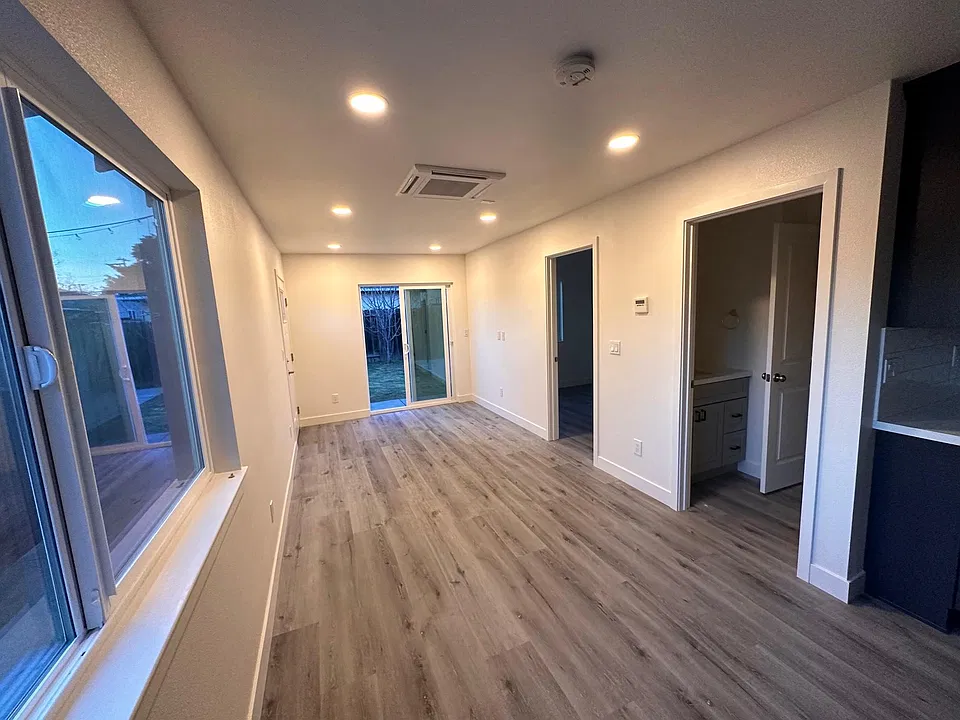 Living room with front-door entry (left wall) and sliding doors for backyard access.