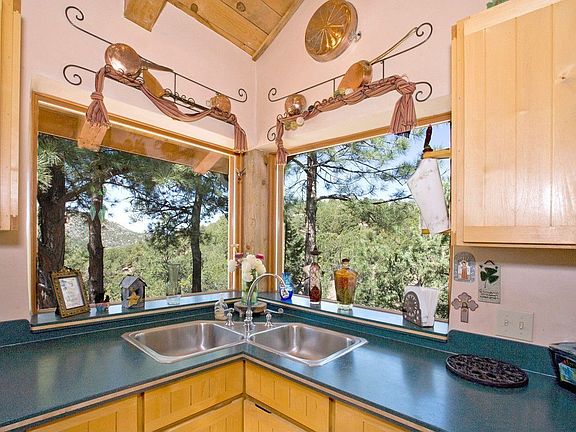 Above the dbl stainless-steel corner sink, window provide breathtaking view
