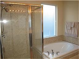 Posh master bathroom with separate shower and garden tub.