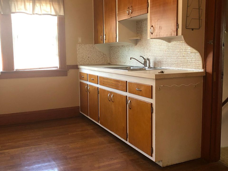Spacious kitchen with beautiful retro cabinetry, Large windows (lots of natural lighting!), Kitchen appliances (Fridge and Stove/Oven) and original hardwood flooring!