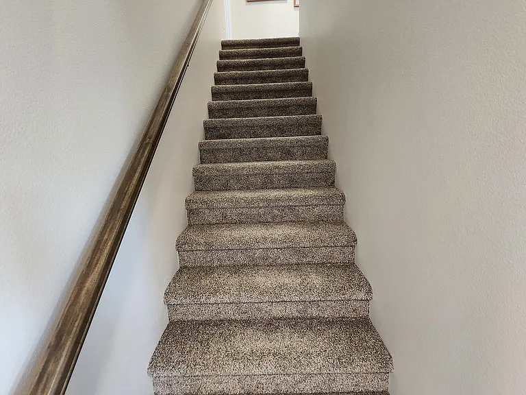 Stairs off the main entrance hallway leading to the upstairs. (Pictures are of another unit with similar finishes and features.)