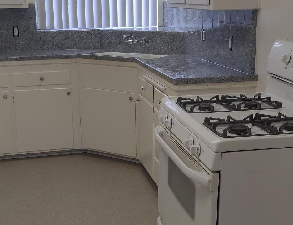Spacious kitchen with new flooring, newly reglazed counter tops and gas stove