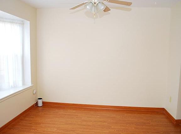 Dining room has neutral paint and a ceiling fan