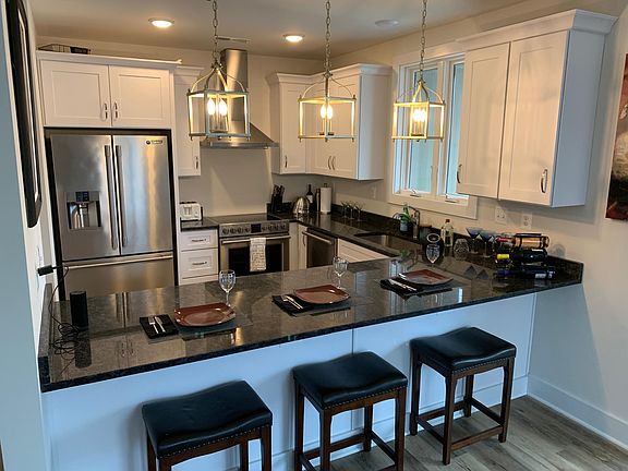 Kitchen with bar; large refrigerator; electric range. (Pantry and laundry in hallway)