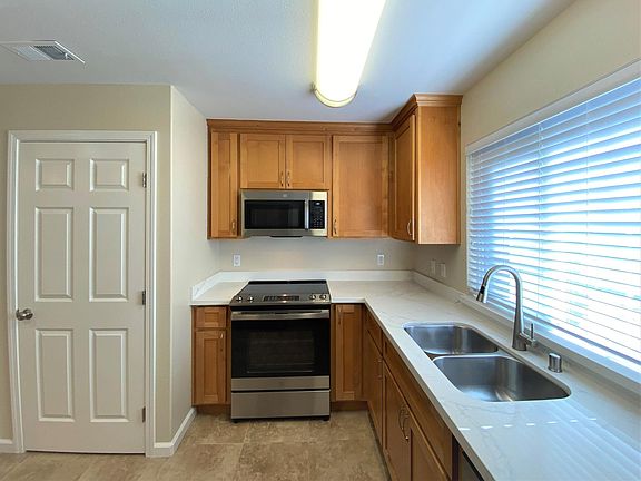 Kitchen with stove, oven, microwave, dishwasher, double-sink and garbage disposal. Quartz countertops.