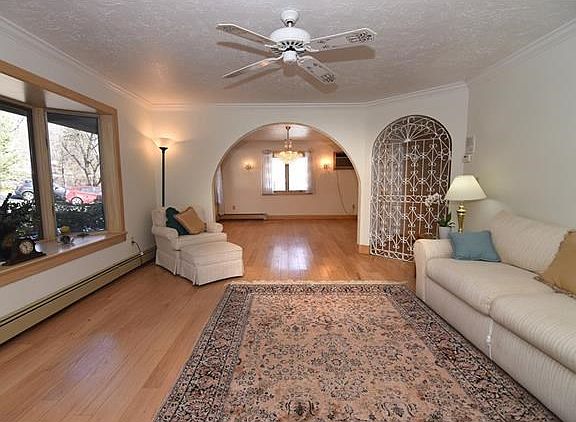 View of the spacious livingroom with hardwod floors looking towards the dining room.