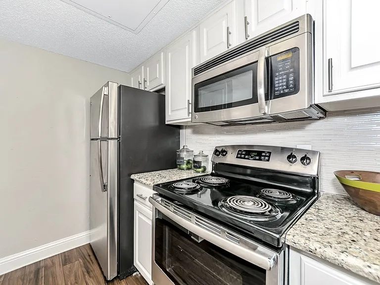 Updated kitchen featuring stainless steel appliances, electric range, built-in microwave, and modern cabinetry with clean finishes.