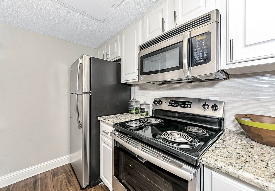 Updated kitchen featuring stainless steel appliances, electric range, built-in microwave, and modern cabinetry with clean finishes.