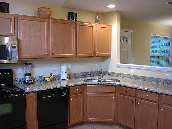 Open kitchen with dishwasher, new range and refrigerator.