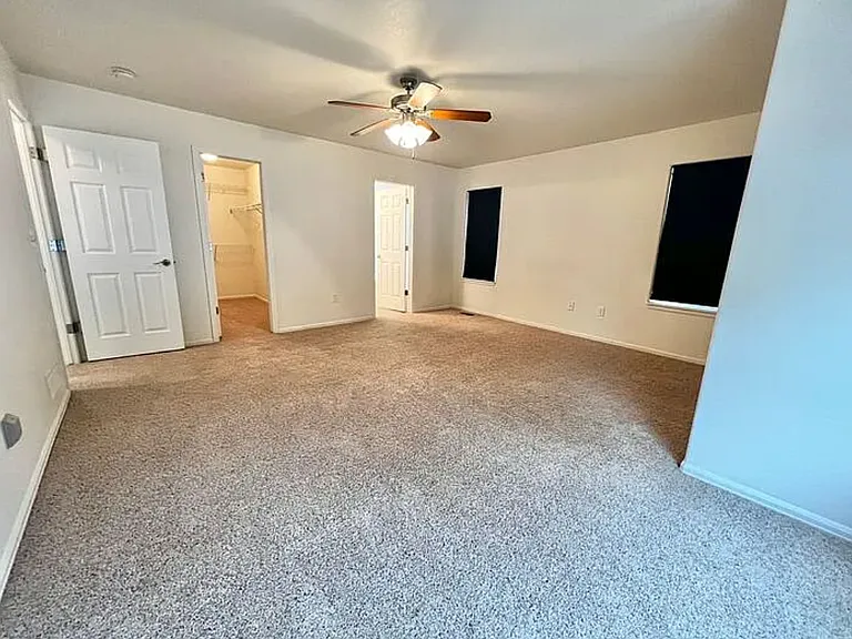 View of the master bedroom taken from the aspect of the bay window area. The door to the master bedroom can be seen on the northern wall to the left. The doors to the walk-in closet and master bathroom are along the eastern wall.