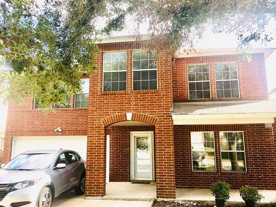 The outside of the building with an oversized driveway which can park four cars.