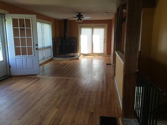 Great room with wood stove on one end, and door to wrap around porch
