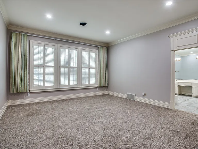 The Primary Suite is spacious and has a wall of windows with a view of the backyard. There is also a cedar closet in the hallway outside the suite. New carpet in 2025. Note: fabric curtains have been removed.