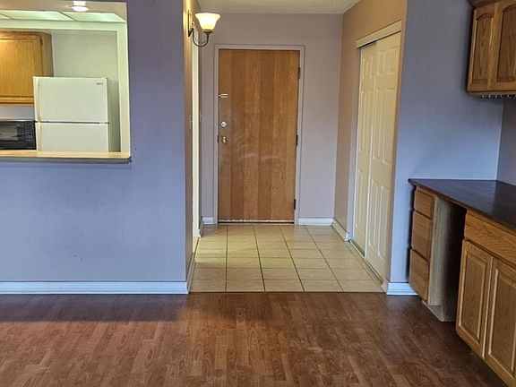 View across living room to kitchen and main entrance. Nice cabinet area in corner of the living room.