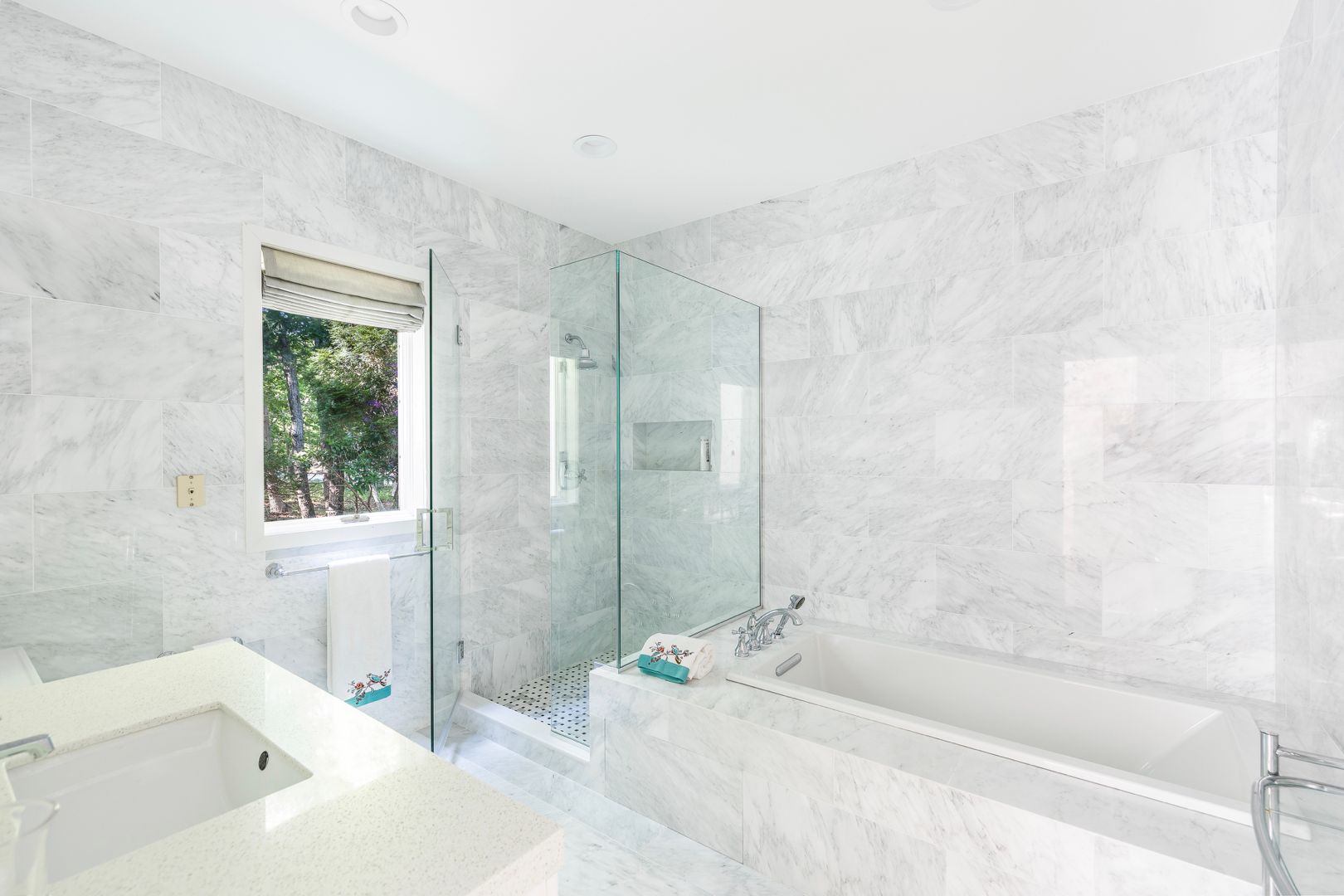  En-suite junior master bathroom features marble interiors. Walk-in rain show, sunken bathtub