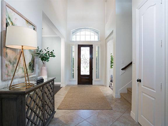 Step inside to a two-story entry with oversized tile set on the diagonal, mahogany front door with wrought iron & sidelights with plantation shutters. Entry is flanked by a formal dining and study with French doors.