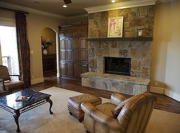 Living area centers on a dramatic fireplace and overlooks the pool.