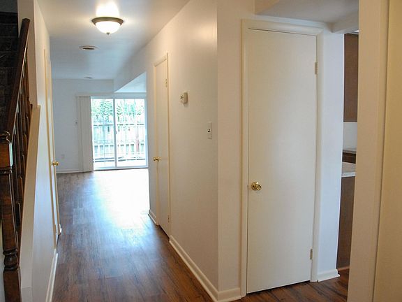 View from front door down hallway to family room. You can see steps on your left to upstairs. On your right you can see opening to kitchen. Another closet door and down hallway door to half bath.