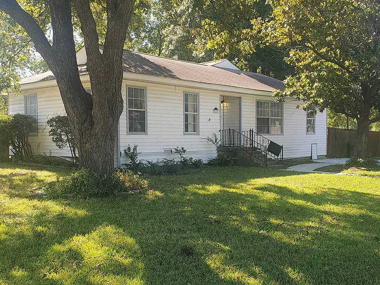 side view of front of house with large pecan tree
