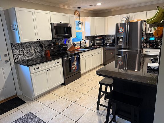 Large kitchen with granite counter tops and lots of storage.