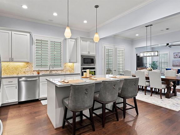 Light and bright kitchen with quartz countertops and stainless steel appliances.
