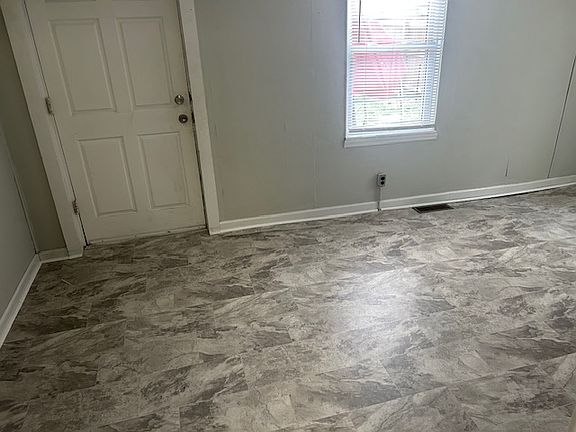 Large laundry has back door that leads to concrete patio & backyard.