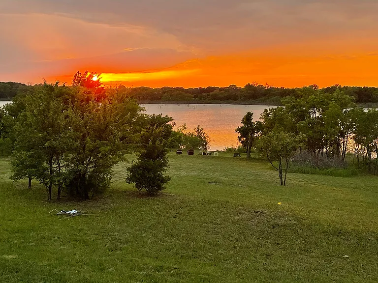 View of the lake at sunset. In the winter months, the trees lose their leaves and open up even more.