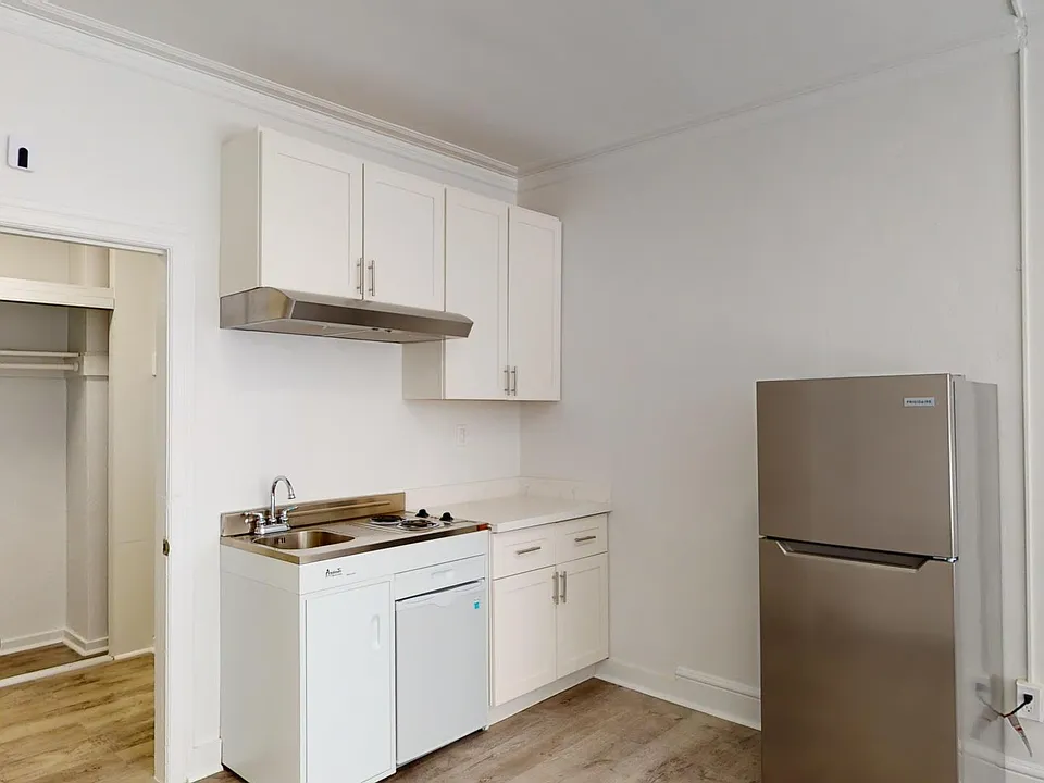 Kitchen with cabinets, refrigerator, sink, stove, and range hood