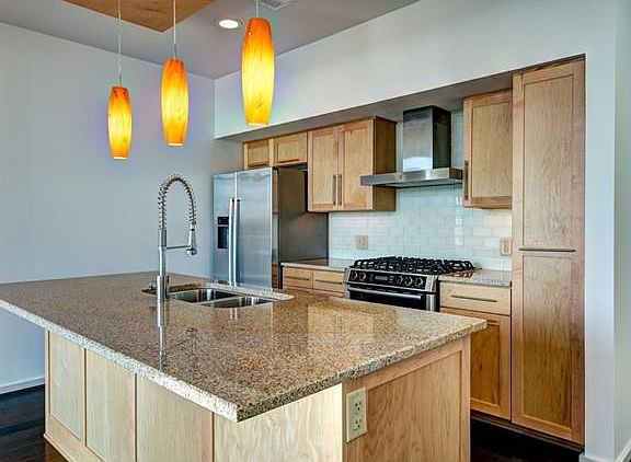 Modern kitchen equipped with stainless Bosch appliances, pul