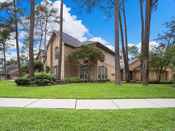 The home has a gorgeous elevation and is surrounded by lush landscaping and established shade trees.