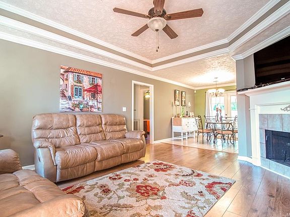 Bright living room with trey ceilings, new fixtures, and fireplace.