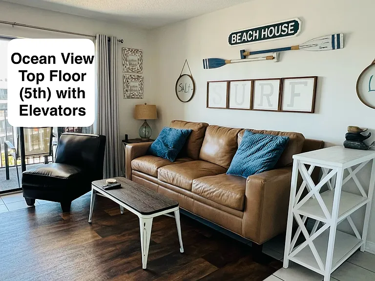 Main living area with large sliding doors, nice bright sunny space and large balcony looking at ocean.